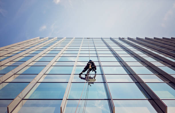 Window cleaner is working on the office building facade.