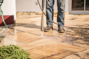 a professional cleaner using pressure washer on cement tiles