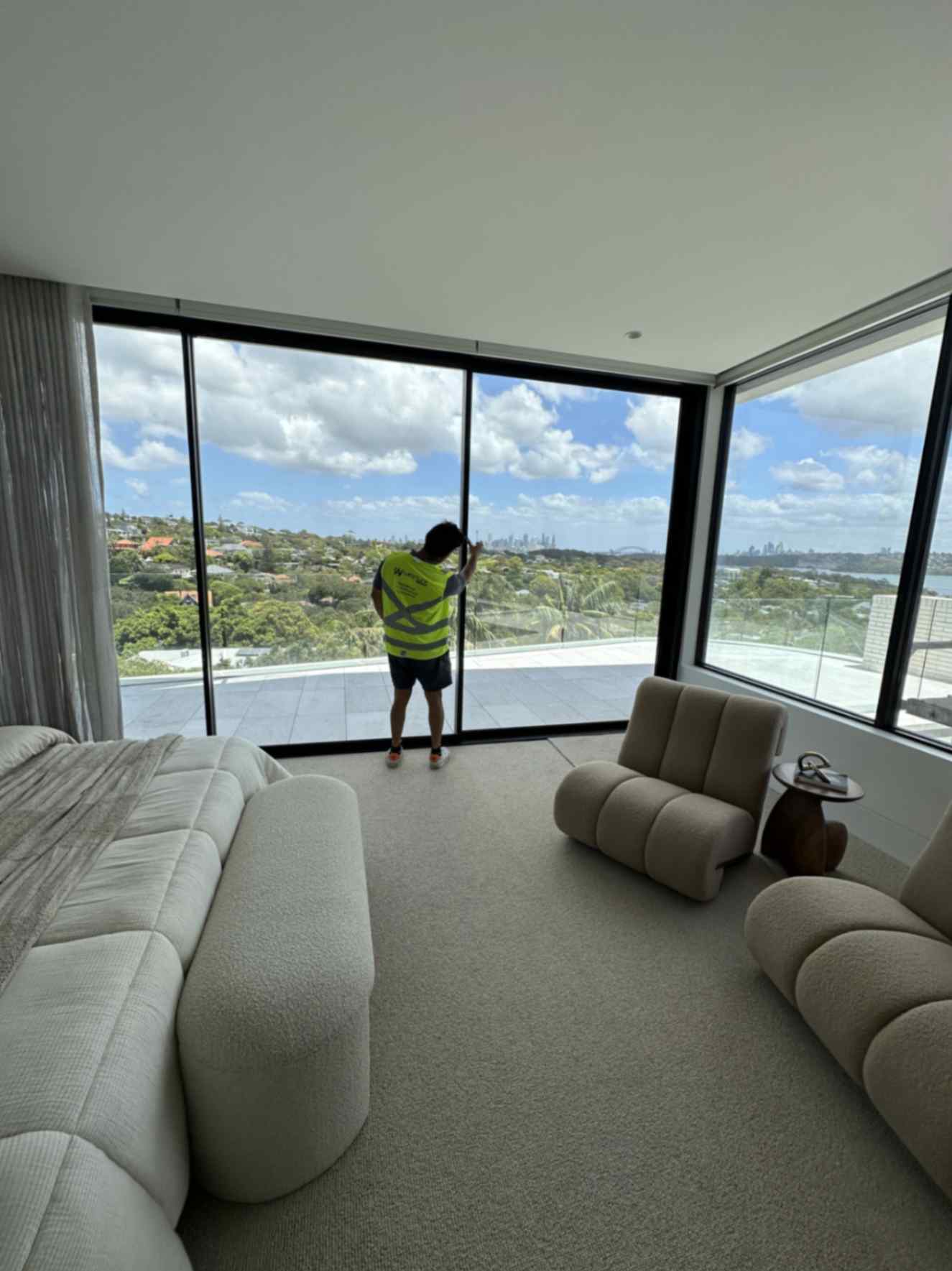 Technicians cleaning large glass windows of a modern building using water-fed poles and pure water systems for streak-free results.