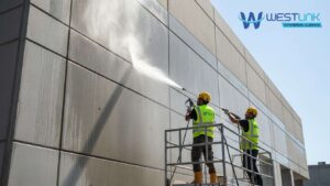 Commercial building exterior being cleaned with high-pressure water by professional cleaners