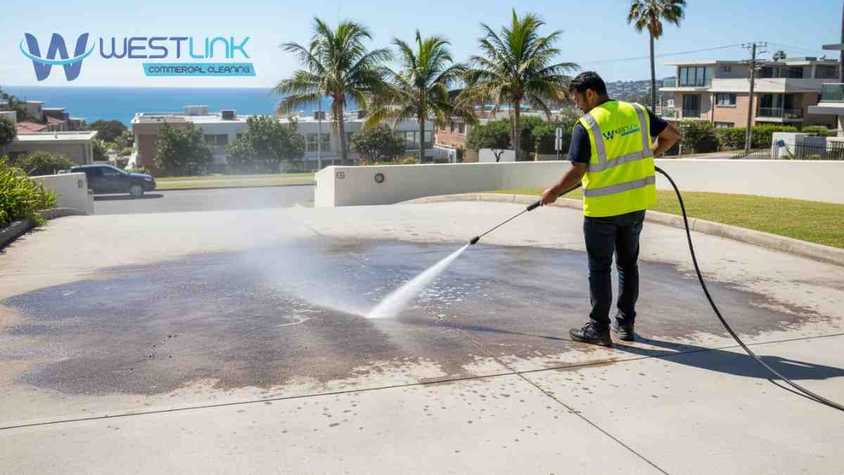 Worker using commercial pressure washer to remove oil and grease from a driveway in Bondi, Sydney.