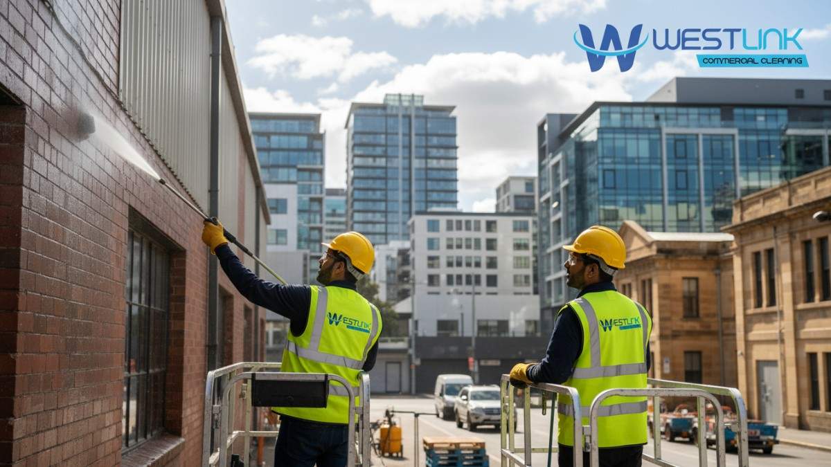 Technicians training on-site while pressure cleaning an industrial building in Ultimo, highlighting mentorship and skill development.