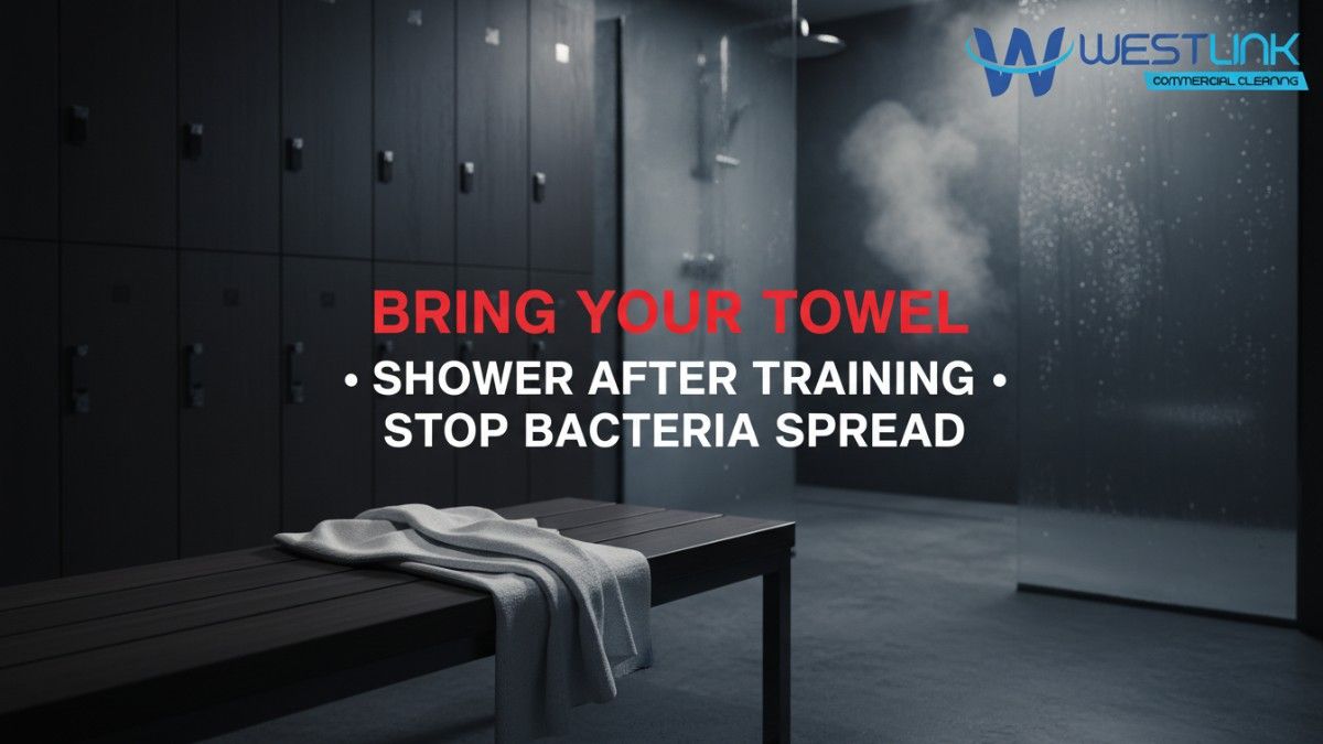 Stylish locker room photo showing a fresh towel on a bench with showers in the background.