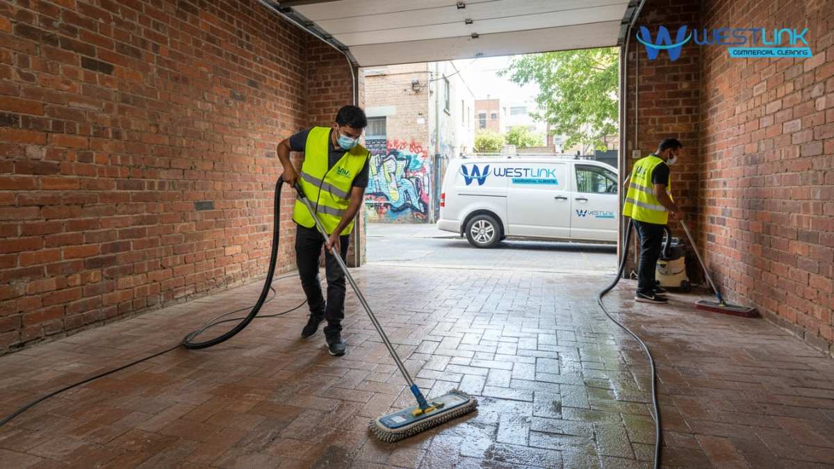 Westink Commercial Cleaners mopping brick garage floor in a Surry Hills terrace.