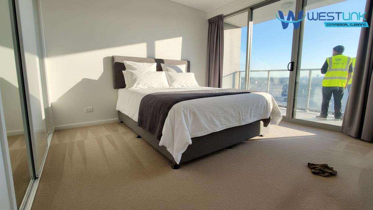 A tidy bedroom in a Blacktown, Sydney apartment, with beige carpets cleaned thoroughly, bed and wardrobe visible.