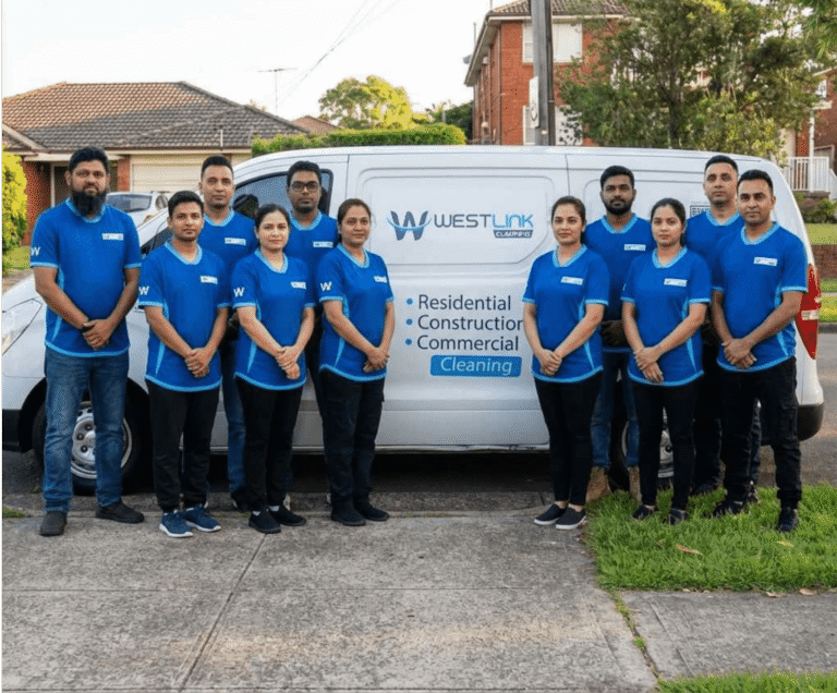 Westlink Commercial Cleaning team of uniformed staff in blue polos is standing in front of a branded company van for cleaning services.