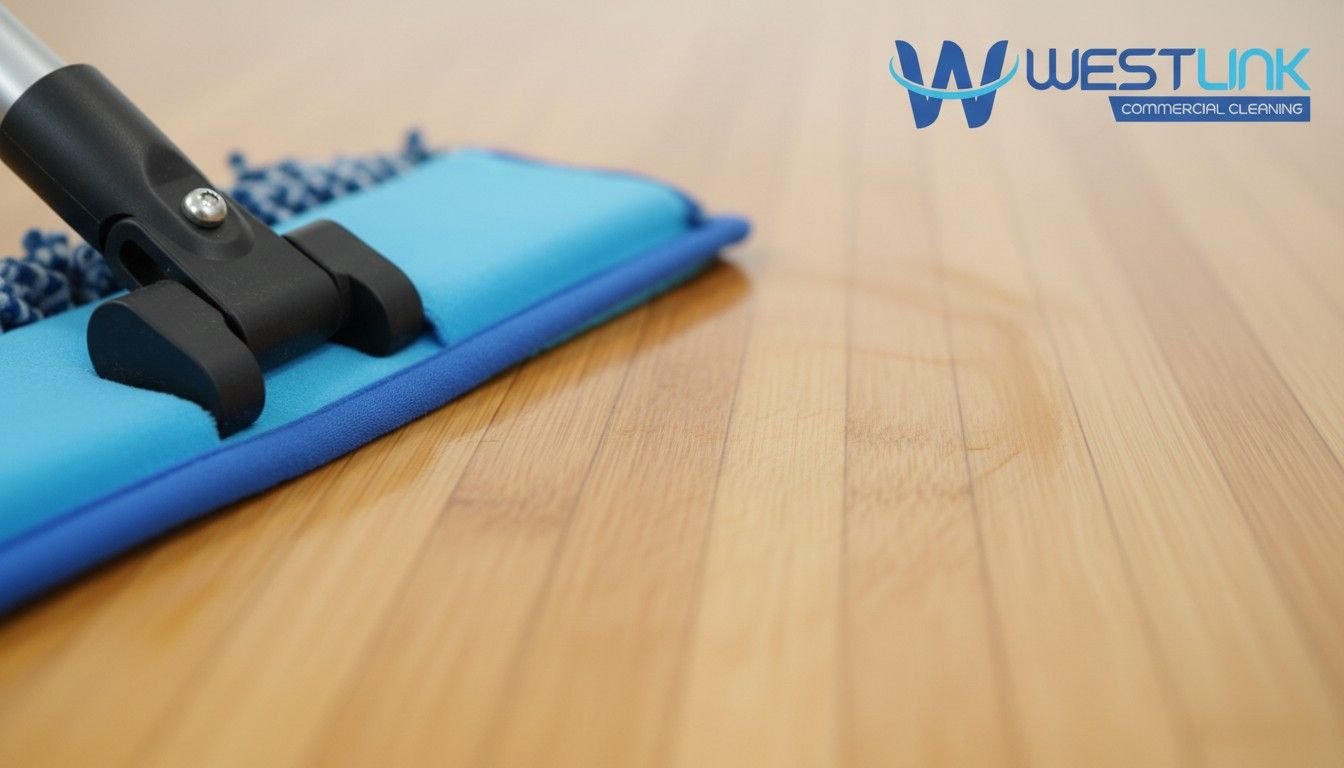 Zoomed close-up of microfiber mop cleaning shiny bamboo floor surface by Westlink Commercial Cleaning